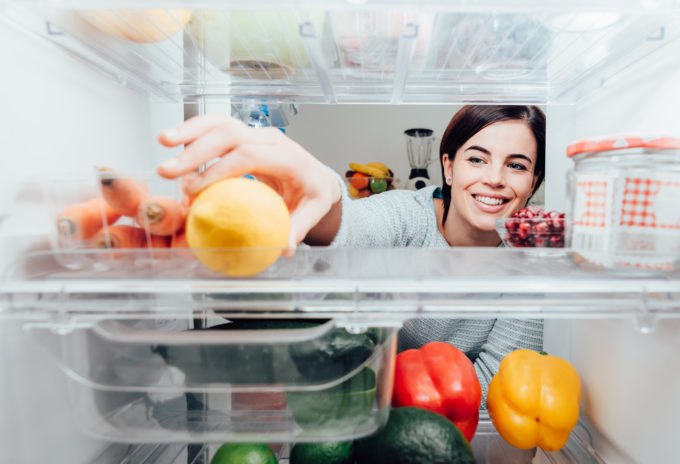 Woman taking lemon out of the fridge